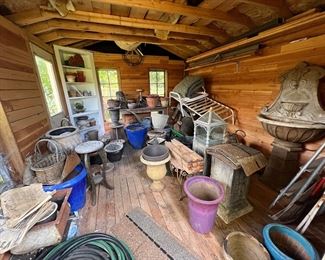 Lots of pots, garden decor, and a wall fountain