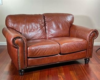 ITALIAN LEATHER LOVESEAT | Divani Chateau d'Ax small brown leather sofa with brass rivets on front border of armrests & base with spindle legs. - l. 62 x w. 37 x h. 37 in
