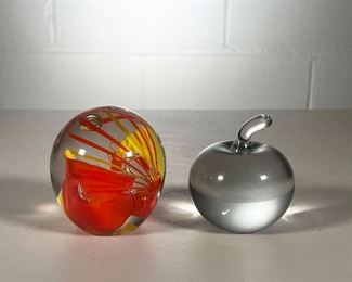 (2PC) GLASS PAPERWEIGHTS | Including one with an orange & yellow design signed by Schneider and one clear glass apple paperweight. - l. 3 x h. 3.25 in (Schneider PW)