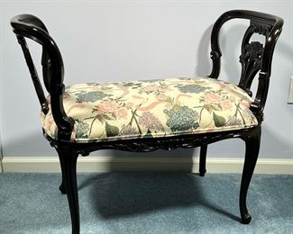 SMALL CUSHIONED BENCH | Dressing bench or vanity seat: carved wood with rounded sides, having floral carved decoration and floral-patterned cushion seat. - l. 34 x w. 18 x h. 28 in