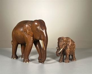 (2PC) CARVED WOODEN ELEPHANTS | Hand-carved wooden elephant figure with a smaller plaster statue.