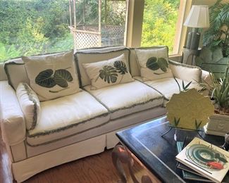 One of two green fringe trim sofas