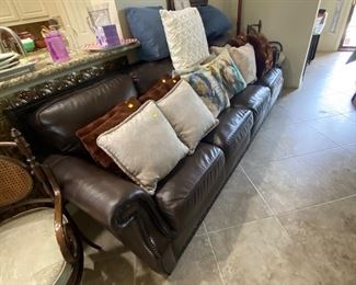 Beautiful brown leather sofa and assorted decorative pillows