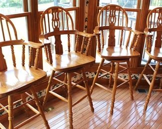 Four golden oak, swivel arm chairs.  They are bar height.