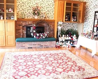 The family room has a large volume of Christmas decorations, a lovely rug and home decor.  