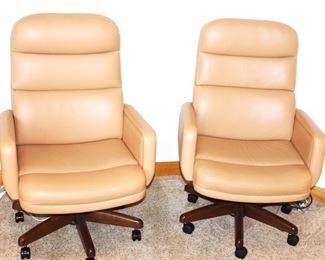 Two leather or leather like swivel, arm chairs.  