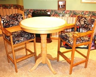 Bar height pool table upholstered chairs and round tiled bar top table.