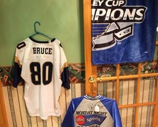 St. Louis Rams Football Player Isaac Bruce #80 Jersey,  St. Louis Rams Football Player D'Marco Farr  autographed jacket, and St. Louis Blues Hockey Stanley Cup Champions throw.