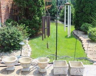 Variety of concrete planters, wind chimes and other  outdoor items.
