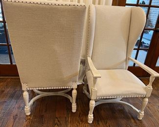 Front and back of wing back chairs. There is a nail head trim around the bottom of the fabric seats.