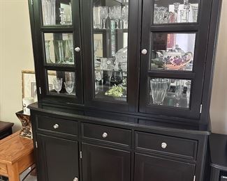 Black hutch 53.5” wide x 20” deep x 77.5” tall, assorted crystal candlesticks, vases and dishes