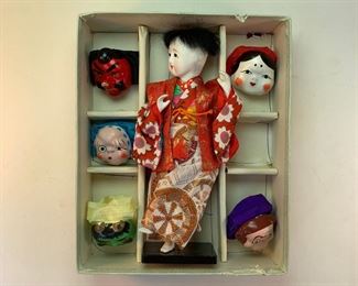 Vintage Japanese doll with an assortment of theatrical masks.
