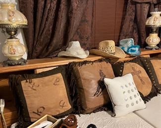 leather covered decorative pillows and cowboy hats