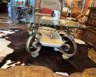 metal and glass coffee table and cowhide rug
