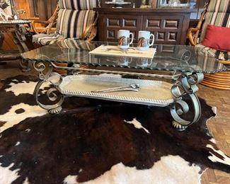 metal and glass rectangular coffee table and cowhide rug