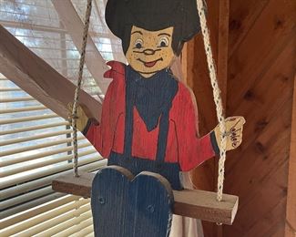 articulated wooden cowboy on swing