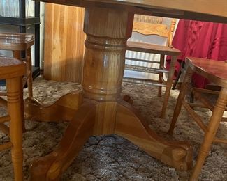 round, pedestal base oak table with pressed-back chairs