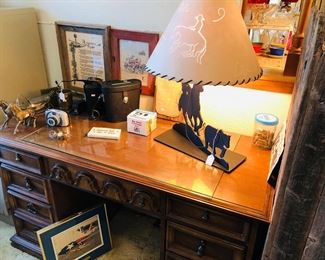 Desk, binoculars, cut iron western lamp, rattlesnake rattlers. 