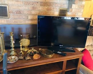 Small entertainment cabinet, tv, brass candlesticks.
