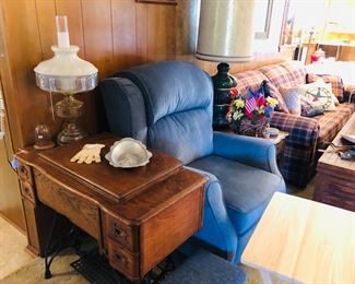White tredle sewing machine in beautiful oak case, beautiful vintage lamp, power recliner and sleeper sofa.