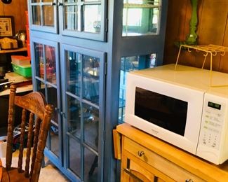 Soldier blue cabinet, microwave and small cabinet underneath microwave.