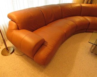 Item 1: Five-piece modern brown (cognac color) curved leather sectional sofa with adjustable back. Brand name not found. Both end pieces each measure 65” wide x 42” deep x 30” tall (with closed back). Three center sections each measure 40” wide x 42” deep x 30” tall (with closed back). PRICE: $1,995.00