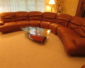 Item 1: Five-piece modern brown (cognac color) curved leather sectional sofa with adjustable back. Brand name not found. Both end pieces each measure 65” wide x 42” deep x 30” tall (with closed back). Three center sections each measure 40” wide x 42” deep x 30” tall (with closed back). PRICE: $1,995.00