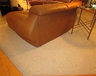 Item 2: Two-piece modern brown (cognac color) curved leather sectional sofa with adjustable backs and with (2) rolling ottomans. Brand name not found. Each section measures 65” wide x 42” deep x 30” tall. Each ottoman measures 40” wide x 25” deep x 18” tall. PRICE: $1,895.00