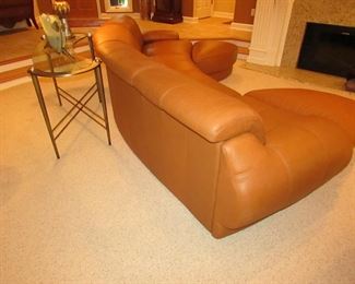 Item 2: Two-piece modern brown (cognac color) curved leather sectional sofa with adjustable backs and with (2) rolling ottomans. Brand name not found. Each section measures 65” wide x 42” deep x 30” tall. Each ottoman measures 40” wide x 25” deep x 18” tall. PRICE: $1,895.00