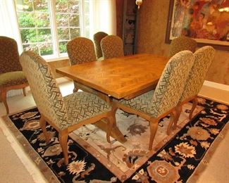 Item 4: Cellura Designs French Country-style pine trestle dining table with herringbone parquetry top, one 2’ leaf, and (8) side chairs. Table without the 2’ leaf measures 6’2” long x 42” wide x 29” tall. Each chair measures 21” wide x 23.5” deep x 42” tall. PRICE: $2,995
