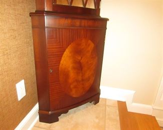 Item 12: Lighted bowfront corner cabinet with inlay. Not marked with brand name. 73” tall x 18” deep. 25” from each back corner to front. PRICE: $575.00