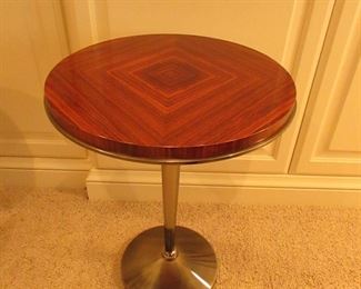 Item 13: Contemporary wooden and metal accent table with brushed nickel finish to metal. Brand name not found. 2’ tall x 18.5” diameter. PRICE: $195.00