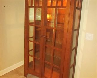 Item 16: Cherry Mission-style lighted curio cabinet. Brand name not found. 70.25” tall x 44” wide x 15.5” deep. PRICE: $750.00
