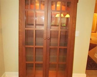 Item 16: Cherry Mission-style lighted curio cabinet. Brand name not found. 70.25” tall x 44” wide x 15.5” deep. PRICE: $750.00