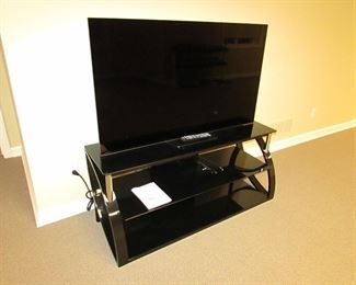 Item 47: Sony Bravia 55” XBR-55A8F OLED smart TV with contemporary Bell O’ metal and glass media stand. Media stand measures 52” wide x 22.25” tall x 17.5” deep. PRICE: $650.00