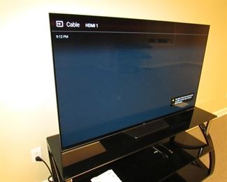 Item 47: Sony Bravia 55” XBR-55A8F OLED smart TV with contemporary Bell O’ metal and glass media stand. Media stand measures 52” wide x 22.25” tall x 17.5” deep. PRICE: $650.00