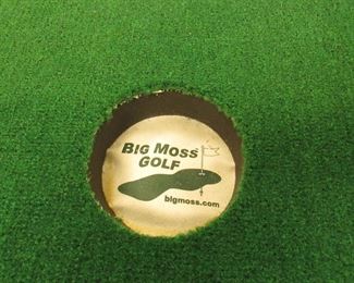 Item 48: “Big Moss Golf” 2-hole indoor putting green (mat). 12’ long at longest point x 4’ wide at widest point. Rolls for easy transport. PRICE: $125.00