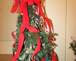 Item 62: TWO matching pre-lit pencil trees with bows, filler, and LED lights. Approximately 74” tall x 19” at widest point. PRICE: $150.00