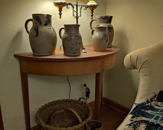 Early American crocks and baskets, antique half-round table, antique lamp