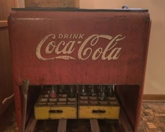 antique Coca-Cola cooler, bottles, and crates