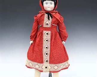 A late 19th century doll. China head with Brown molded hair and painted detail, on a cloth jointed body with porcelain lower arms. Wearing a Red floral dress with lace and matching bonnet. Minor wear, small flake to porcelain hair, felt booties with small holes. 28" long. ESTIMATE $100-200