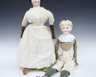 Two 19th century dolls. China heads with molded hair and painted detail, on cloth jointed bodies with leather arms. Includes a doll with Brown painted "flat top" hair wearing a White Swiss dot dress with lace, and a doll with blonde painted curly hair wearing White pantalettes and leather shoes. Minor wear to paint, fabric with some fading and staining, brunette doll with flakes to hair. Up to 27" long. ESTIMATE $100-200