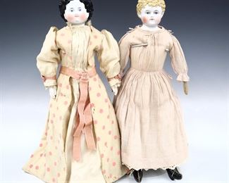 Two 19th century dolls. China heads with molded hair and painted detail, on cloth jointed bodies with incorporated leather boots. Includes a doll with Brown painted "flat top" ringlet hair and porcelain lower arms wearing a Cream and Pink polka dot dress with ribbon, and a doll with blonde painted curly hair wearing a Light Pink floral dress. Minor wear to paint, fabric with some fading, staining and small holes, blonde doll with hairline to face. Up to 23 1/2" long. ESTIMATE $100-200
