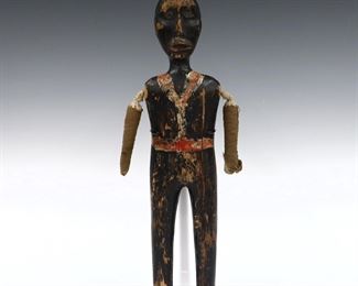A 19th century African American Folk Art carved doll. Male carved wooden figure with rope joined stuffed cloth arms and polychrome painted finish. Wear and some damage, lacks original base. 15" long. ESTIMATE $100-150