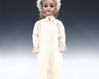 A late 19th century Bergmann, Simon & Halbig doll. Bisque socket head with Blonde hair, sleep eyes, open mouth with teeth, pierced ears and painted detail. On a jointed composite body, wearing a White nightgown with lace and cap. Impressed "CM Bergmann, Simon & Halbig" and "12" at neck. Minor wear to paint, neck stringing loose, some cracks to composite, fabric with slight staining. 26" long. ESTIMATE $100-150