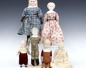 Six 19th to early 20th century dolls. Bisque heads with Blonde molded hair and painted detail on various bodies. Some wear and minor damage, fabric with fading and some stains, one doll lacks an arm. Up to 14" long. ESTIMATE $100-150