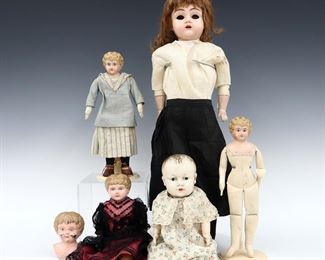 Six 19th to early 20th century dolls and doll head, mostly German. Tin and enameled metal heads with painted detail on various bodies. One marked "Minerva" several marked "Germany". Some wear and minor damage, losses to enamel, fabric with fading and some stains, one doll with ripped arm, largest with loose eyes. Up to 23" long. ESTIMATE $100-150