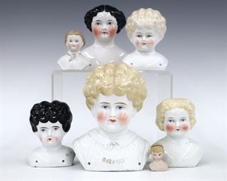 Seven turn of the century China and Bisque porcelain doll heads. Various sizes and hair styles with painted detail. Several marked "Germany", largest marked "Dorothy" at front. Some wear to paint, two with small flakes or chips. 1 1/2" to 6 1/2" high. ESTIMATE $100-200