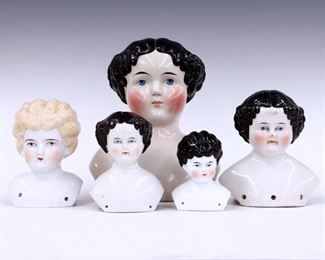 Five turn of the century China doll heads. Various sizes and hair styles with painted detail. One marked "Germany". Some wear to paint, one with small hairline to face, small chips to bases. 3 3/4" to 8 1/2" high. ESTIMATE $100-200