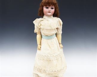 A late 19th century Bergmann, Simon & Halbig doll. Bisque socket head with Red/Brown hair, sleep eyes, open mouth with teeth, pierced ears and painted detail. On a jointed composite body, wearing a White dress with lace and leather shoes. Impressed "CM Bergmann, Simon & Halbig" and "13 1/2" at neck. Minor wear to paint, inner stringing loose, fabric with staining and holes. 30" long. ESTIMATE $100-150